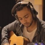 pop rock artist Rance Lazarus in the recording studio playing acoustic guitar