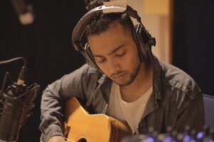 pop rock artist Rance Lazarus in the recording studio playing acoustic guitar