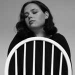 Indie folk Artist Maddie Jackway sitting on chair