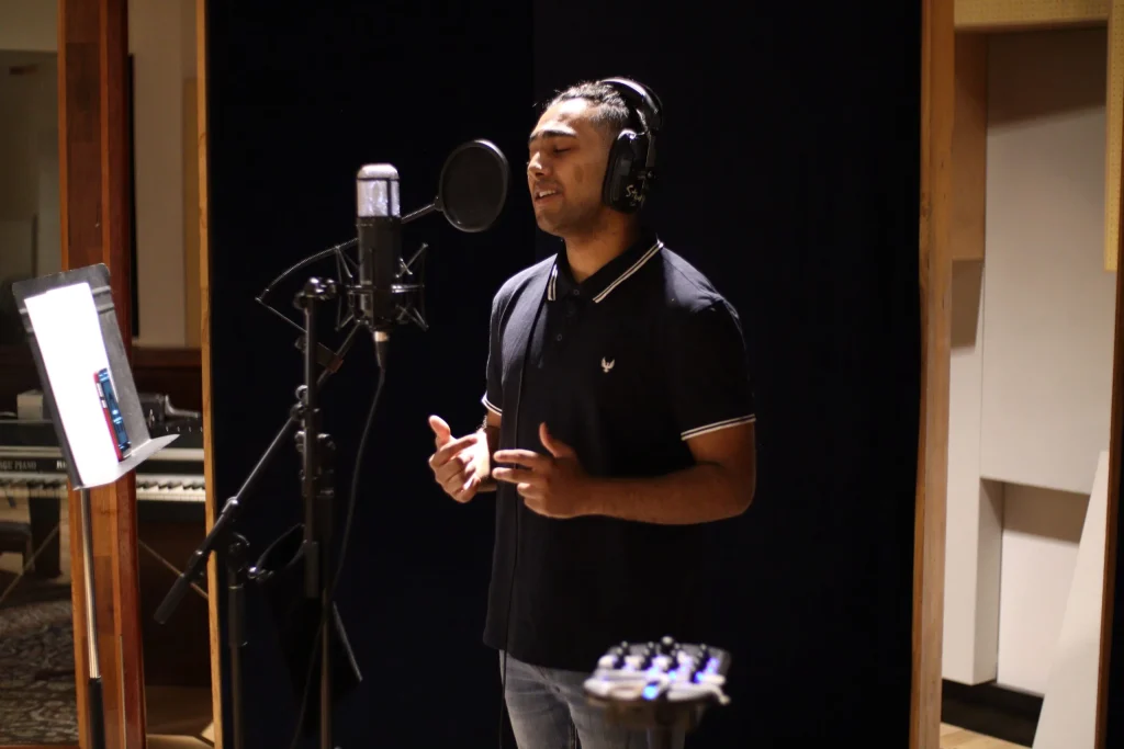 Rance Lazarus recording vocals at the microphone in a studio vocal booth